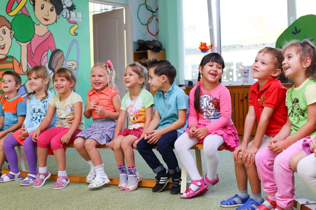 Aufnahme einer Kindergartengruppe, die auf TurnbÃ¤nke sitzt