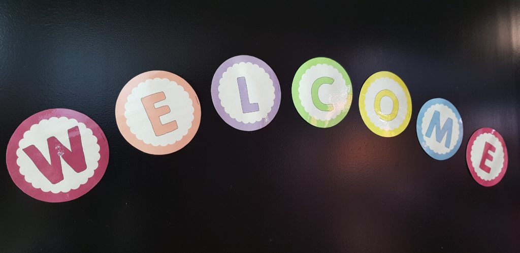 "Welcome" Buchstaben in verschiedenen Farben rund ausgeschnitten
